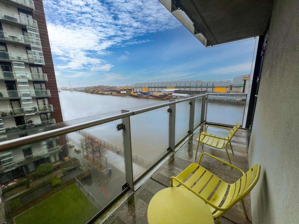a balcony with two chairs and a view of a river at Riverside Retreat with Spectacular Views Glasgow in Glasgow