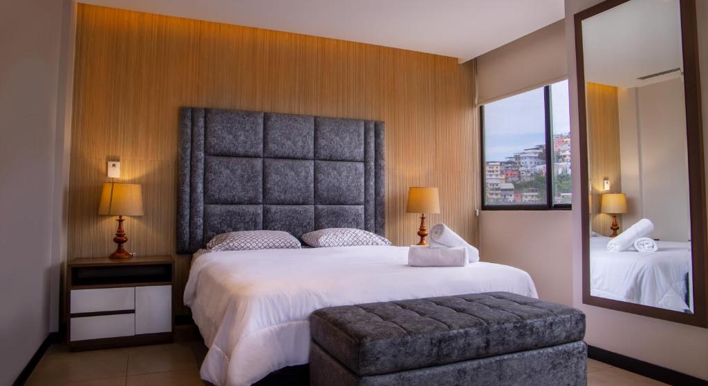 a bedroom with a large bed and a large mirror at Suite 7 Bellini IV, Puerto Santa Ana, Guayaquil in Guayaquil