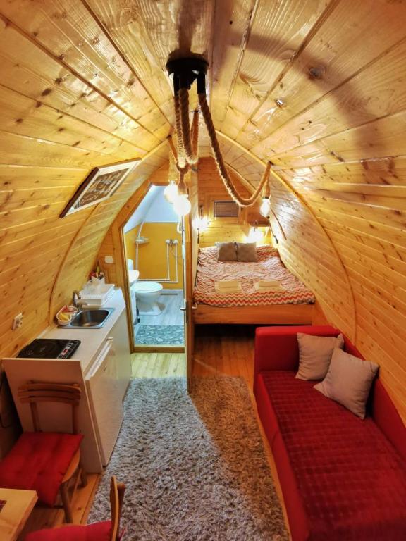Piccola camera con letto e divano rosso. di Vila Jelena - BUNGALOV a Crni Vrh