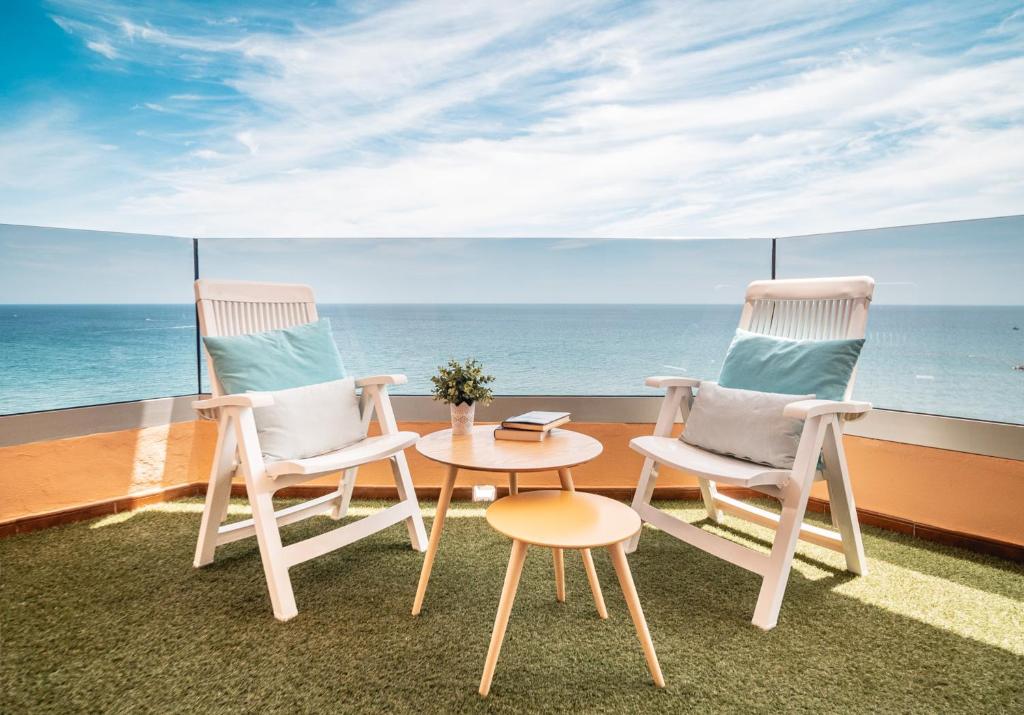 2 stoelen en een tafel op een balkon met uitzicht op de oceaan bij Hotel Angela - Adults Recommended in Fuengirola