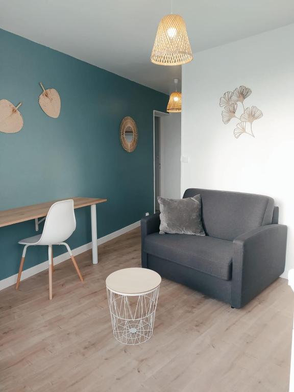 een woonkamer met een bank en een tafel bij O'ZEN - studio calme et lumineux avec jardin in Sablé-sur-Sarthe