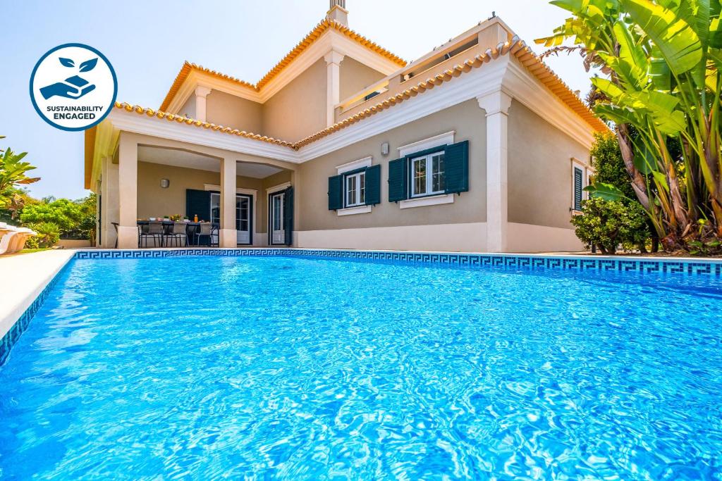 a villa with a swimming pool in front of a house at Villa Hawaii by Algarve Vacation in Albufeira