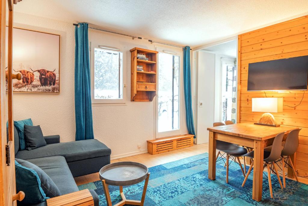 uma sala de estar com uma mesa e um sofá em Apartment Triolet Jardin em Chamonix-Mont-Blanc