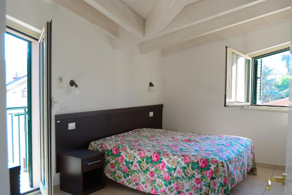 a bedroom with a bed with a floral bedspread at Appartamenti Vacanza in Roseto degli Abruzzi