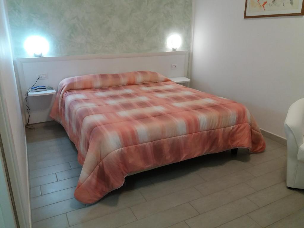 a hotel room with a bed with a striped blanket at Hotel Costa in Bari