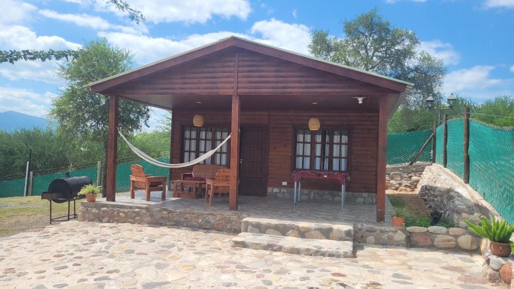 une petite cabane en bois avec un hamac. dans l'établissement Cabaña Los Abuelos, à Coronel Moldes