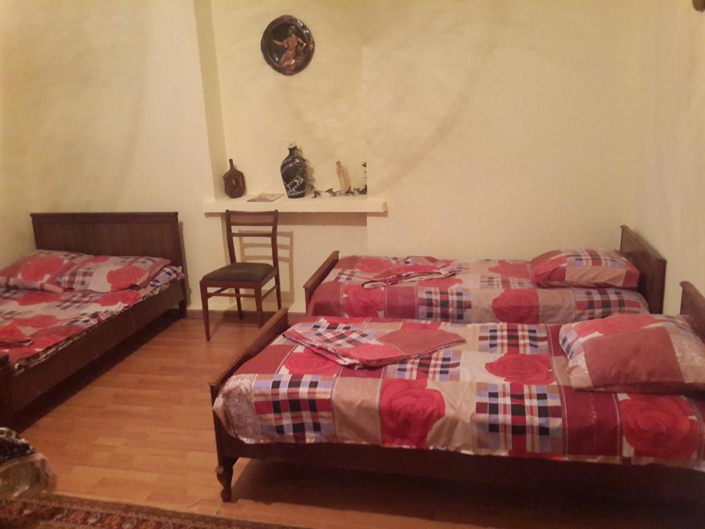 1 dormitorio con 2 camas, mesa y sillas en Lemon Family GuestHouse, en Tiflis