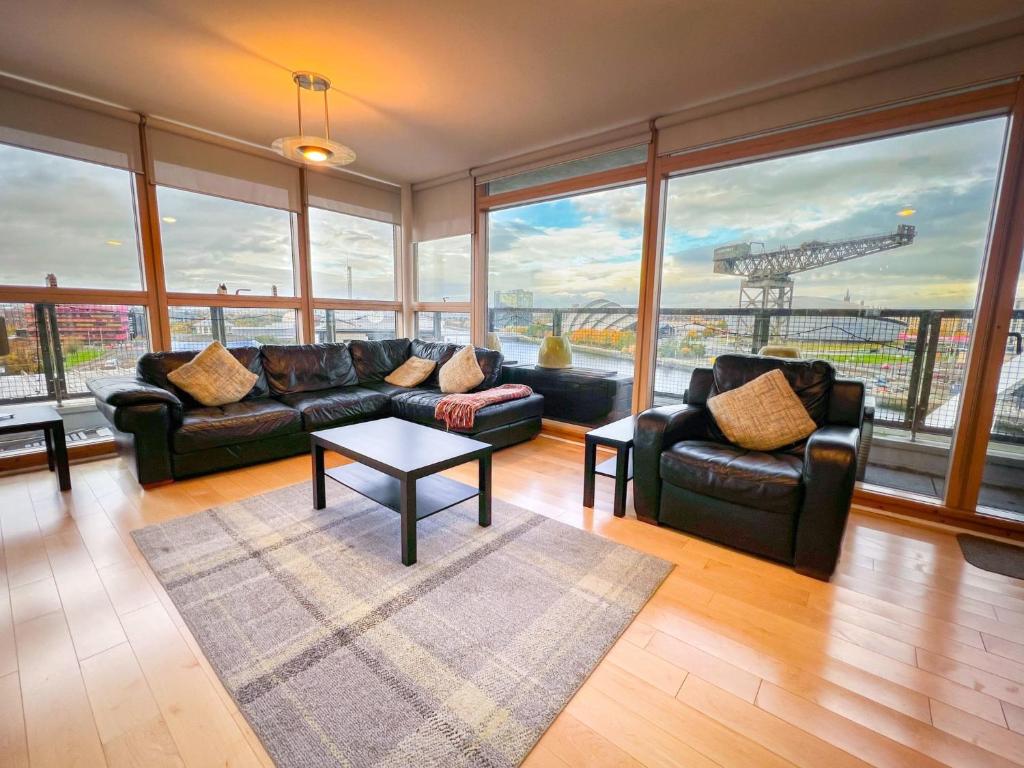 a living room with a couch and a table at Duplex Apartment next to Hydro with Parking in Glasgow