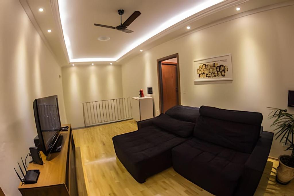 a living room with a couch and a television at Casa ampla e confortável próxima ao Santuário in Aparecida