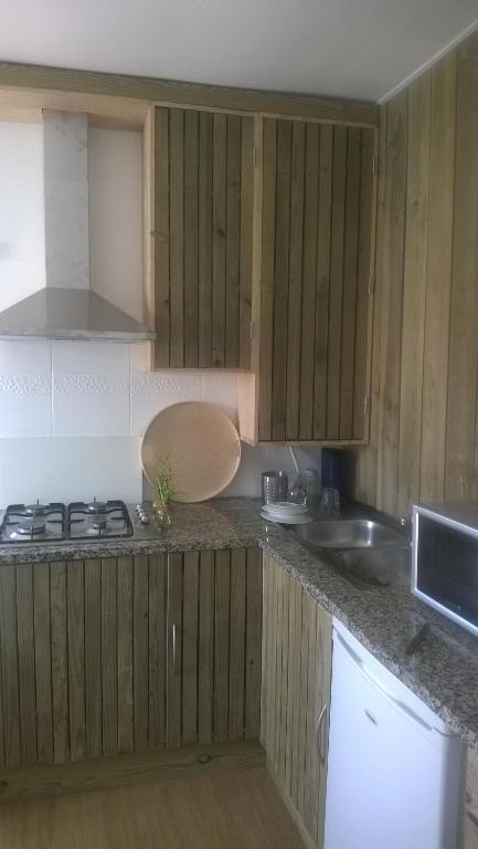 a kitchen with wooden cabinets and a counter top at Pensao Sisudo in Sintra