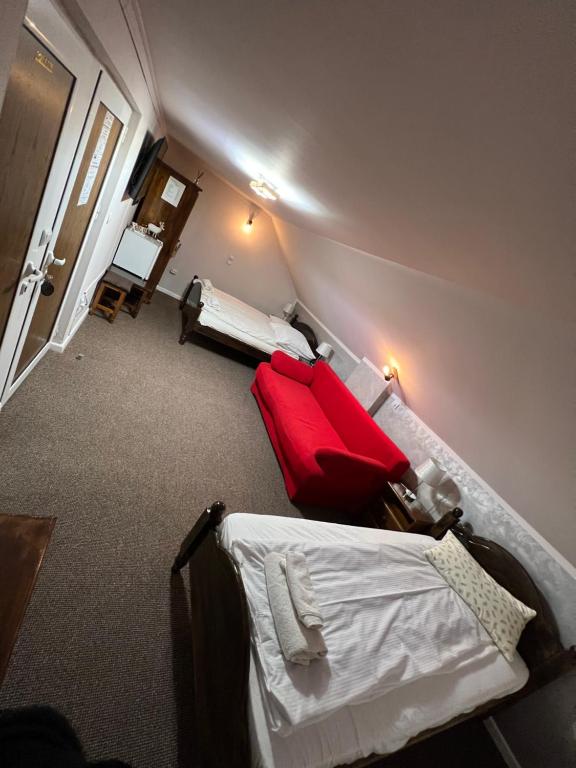 una habitación con 2 camas y una maleta roja en Pensiunea Sandra, en Ocna Şugatag