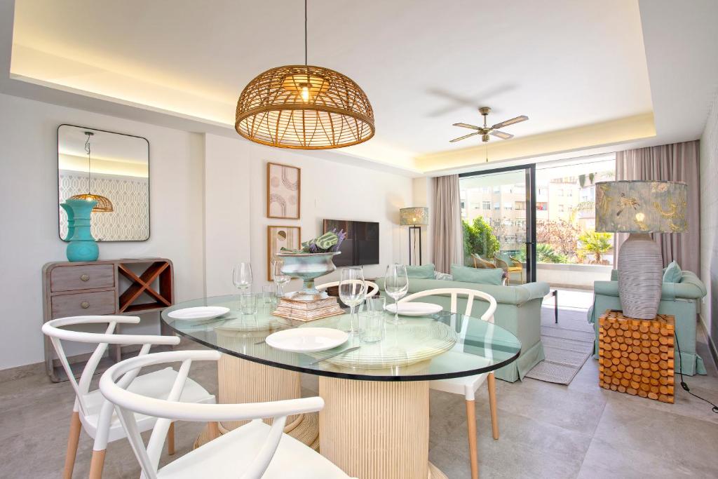 una sala da pranzo e un soggiorno con tavolo e sedie di Genteel Home Infinity a Estepona