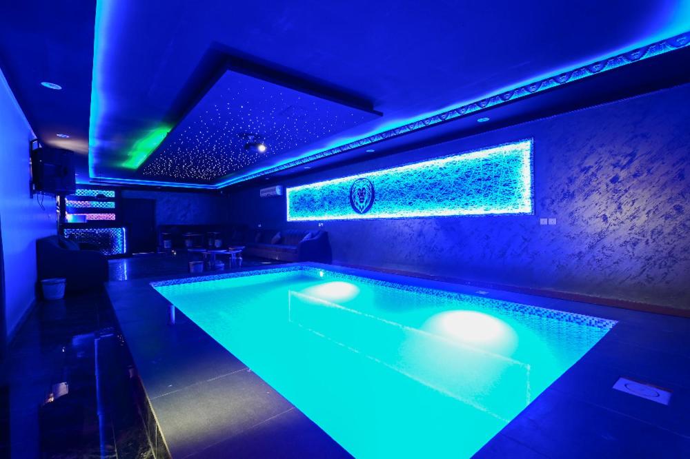 una piscina en un bar con luces azules en شاليهات يارا القيروان en Riad