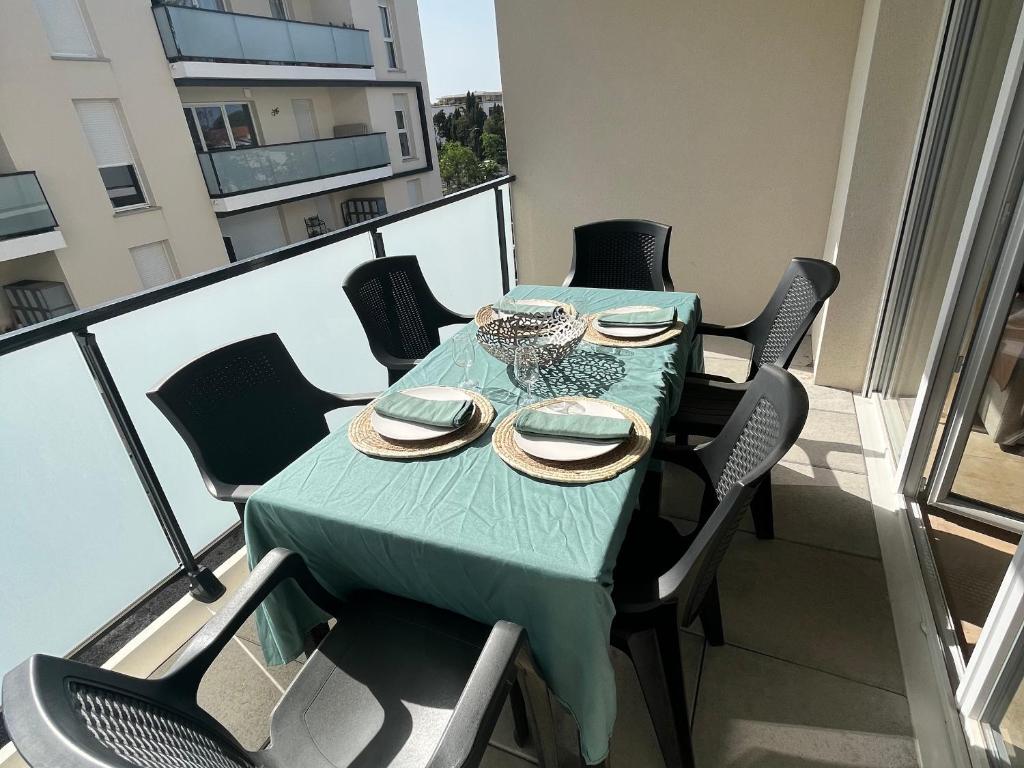 une table avec un tissu de table vert sur un balcon dans l'établissement T3 neuf climatisé avec terrasse, piscine et parking à Argelès-sur-Mer - FR-1-732-27, à Argelès-sur-Mer