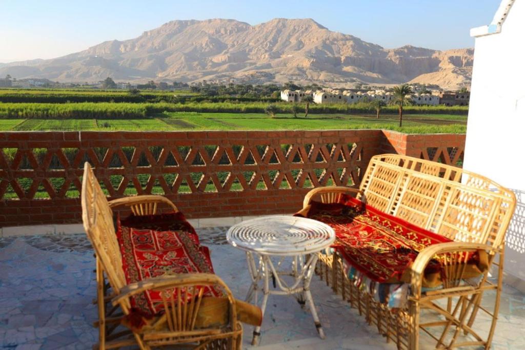 een patio met een tafel en stoelen en uitzicht op de bergen bij Calm moon nights hostel in Al Aqālitah