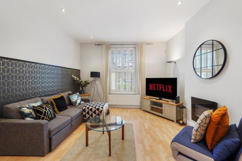 a living room with a couch and a tv at Pristine Stylish Townhouse on the Stray - Sleeps 8 in Harrogate