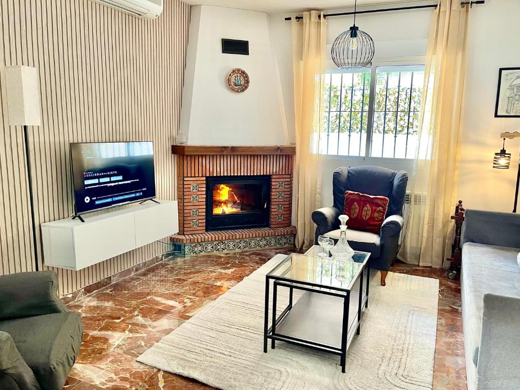 uma sala de estar com lareira e televisão em Casa rural Lomalinda em Granada