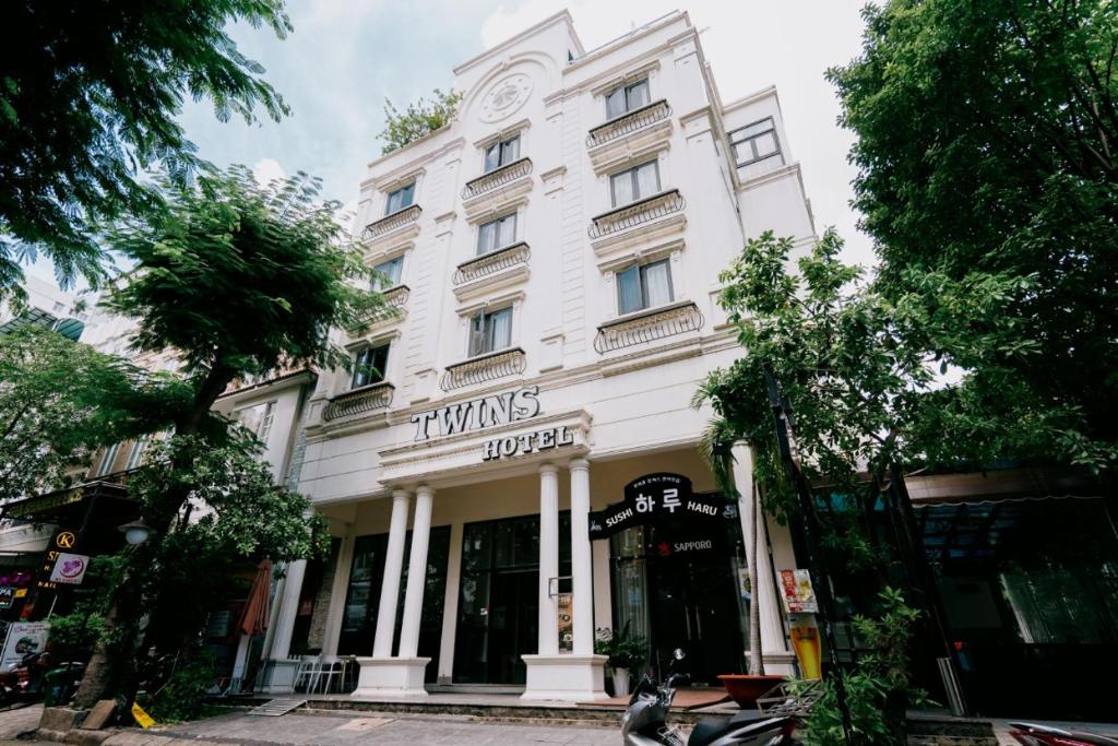 a white building with a sign on it at Twins Hotel in Ho Chi Minh City