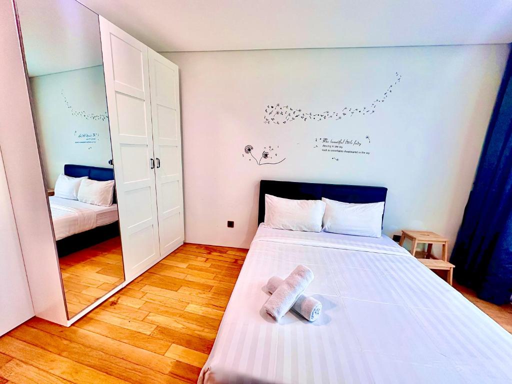 een kleine kamer met een bed en een spiegel bij vortex suites klcc Adela Suites in Kuala Lumpur