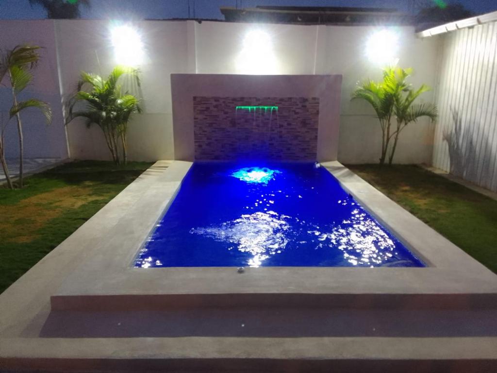 een zwembad in het midden van een tuin 's nachts bij Suite 2, General Villamil Playas in Playas