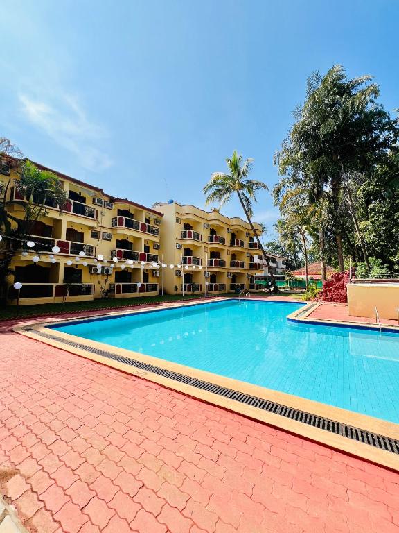 a large swimming pool in front of a building at Abalone Resort in Arpora