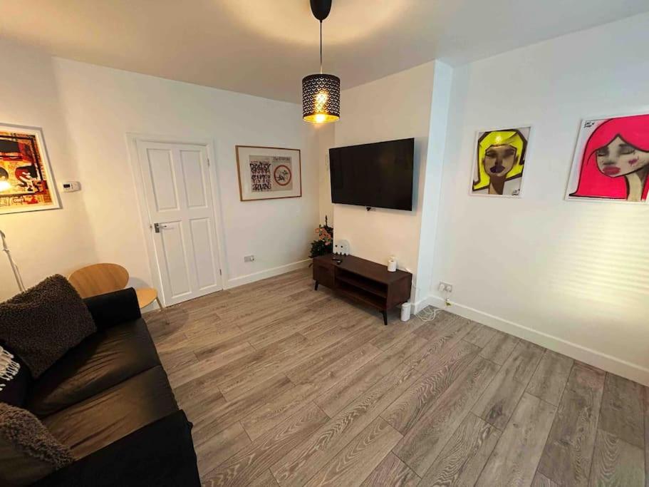 a living room with a couch and a flat screen tv at Cool 2 Bed Hornchurch House, Arcade Games, Free Parking in Hornchurch