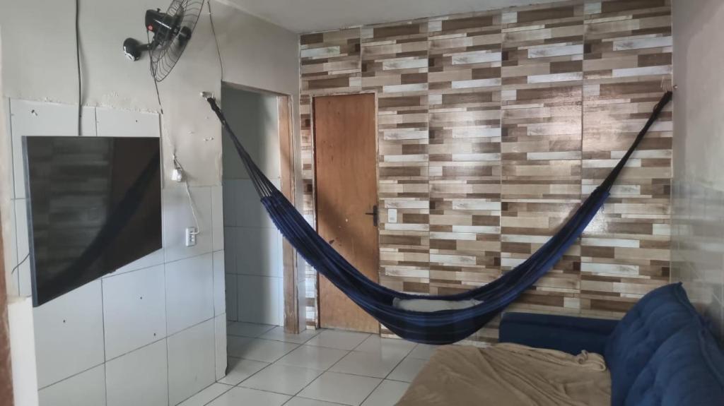 a hammock in a room with a brick wall at Caucaia Cit in Caucaia
