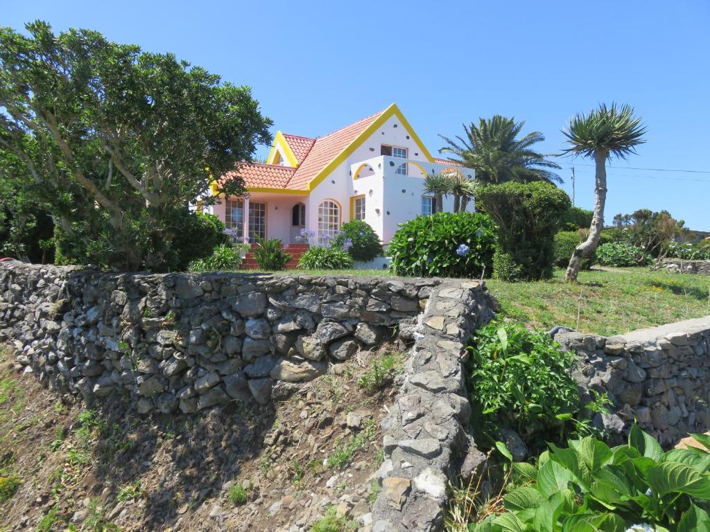 a house with a stone wall in front of it at Villa Cedros in Santa Cruz das Flores