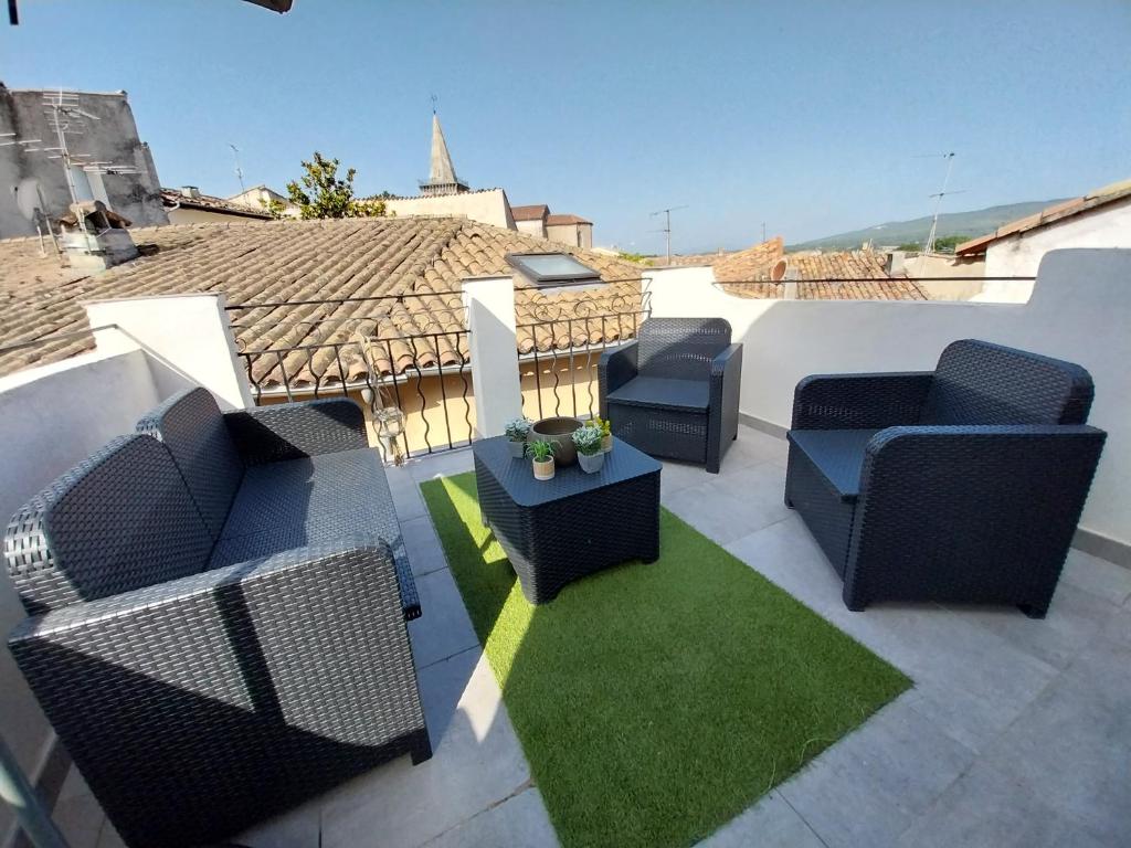 een patio met stoelen en een tafel op een dak bij Sunset APPART in Brignoles