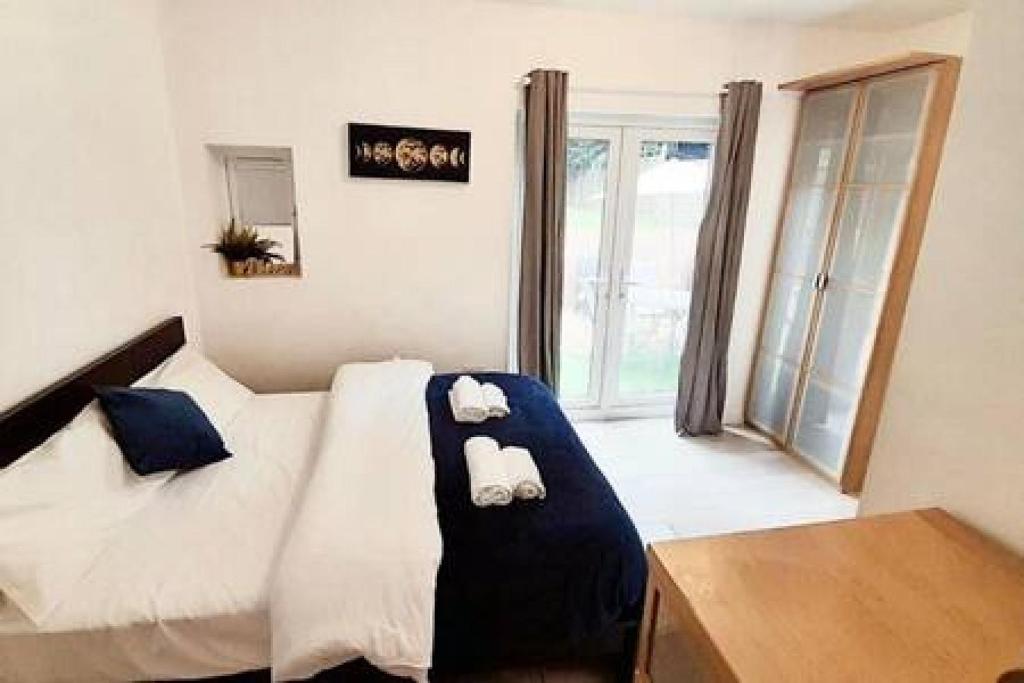 ein Schlafzimmer mit einem Bett mit zwei Handtüchern darauf in der Unterkunft Luxurious Ensuite in Edgware