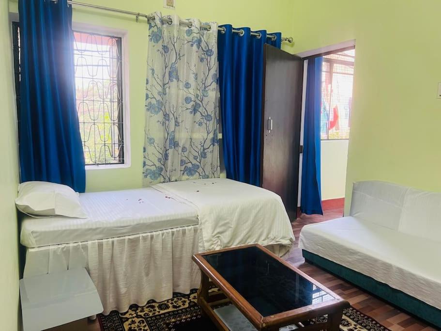 a room with two beds and blue curtains at AV Homestay in Varanasi