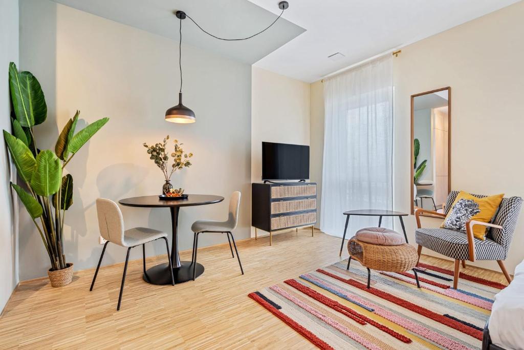 ein Wohnzimmer mit einem Tisch und Stühlen sowie einem TV in der Unterkunft All in Studio with Private Parking City Lux ID219 in Luxemburg (Stadt)