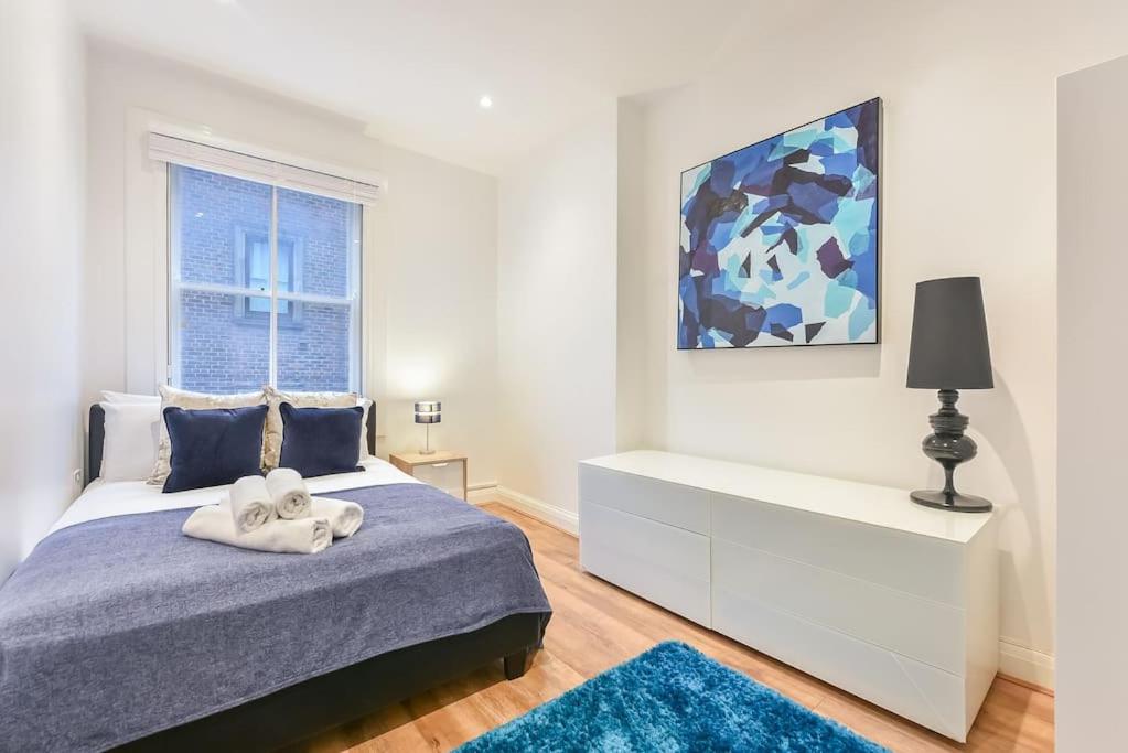 a white bedroom with a bed and a window at 2 Bed Piccadilly Apartment- 1 in London