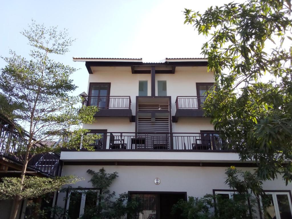 a building with a balcony and trees at The Chill River-Boutique Villa in Siem Reap