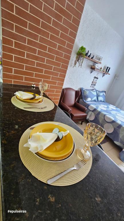 dos platos y utensilios están sentados en una mesa en Apê210MiguelPereira, en Miguel Pereira