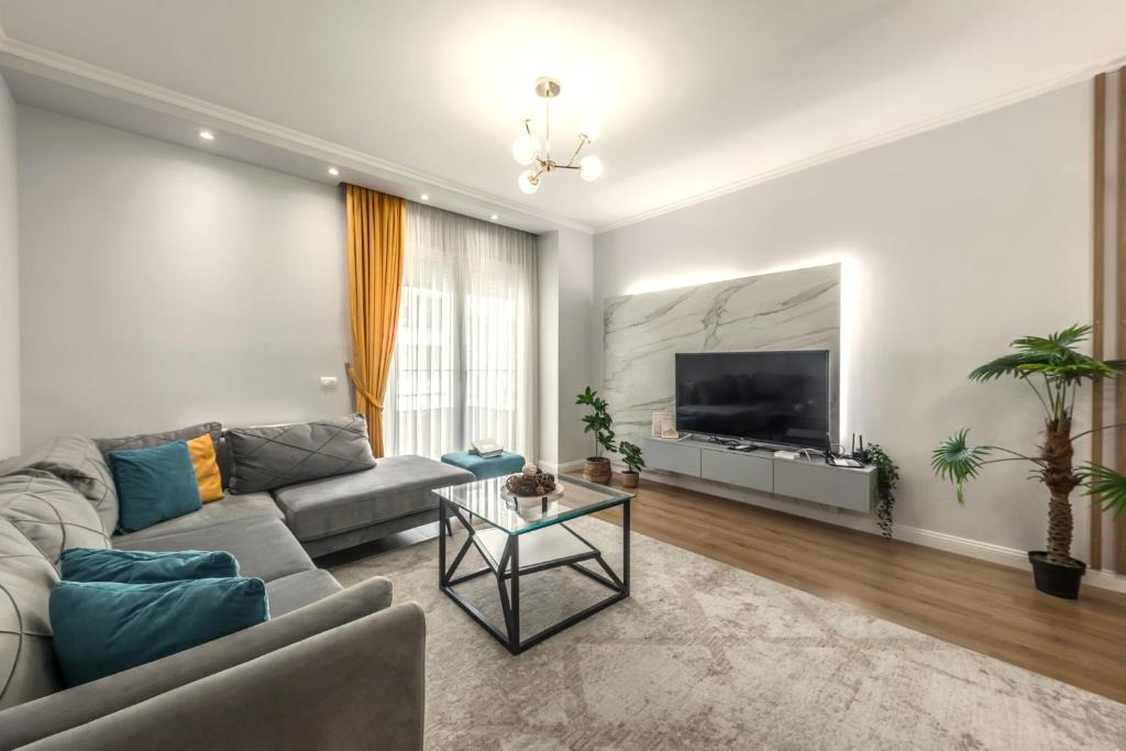 a living room with a couch and a flat screen tv at Luxurios Modern Apartment Marina Bay in Durrës