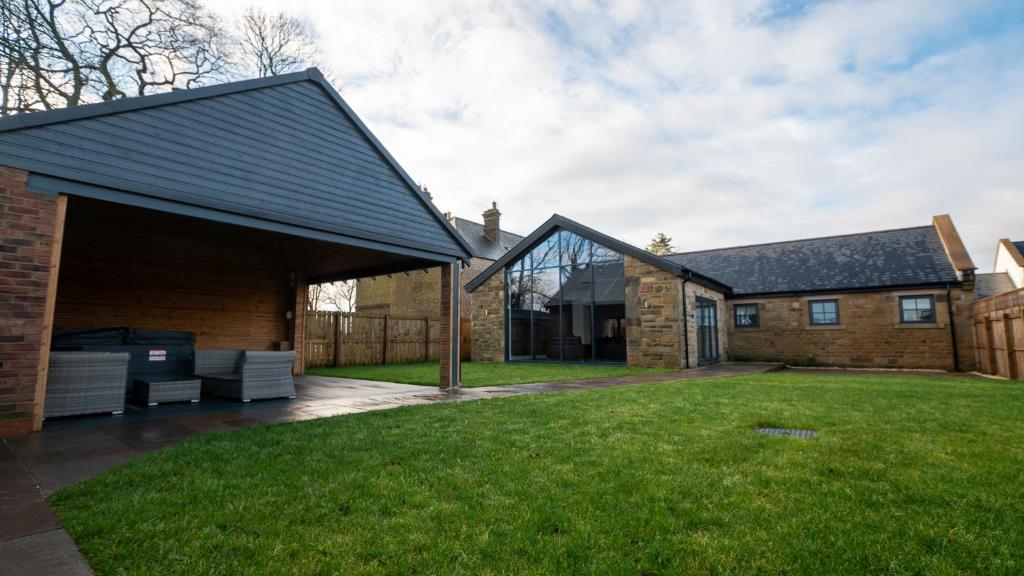 a brick house with a black roof at Northumberland Luxury Stays - The Shearling in West Chevington