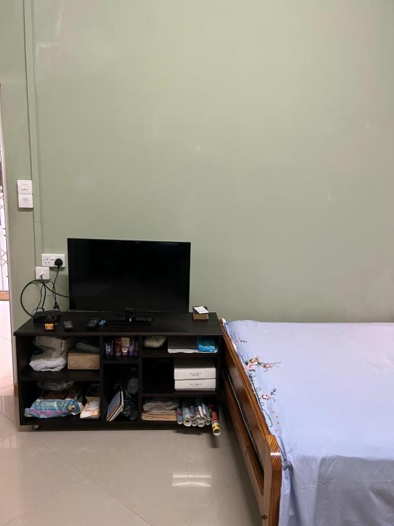 a room with a bed with a television on a table at VMKY apartments in Triolet