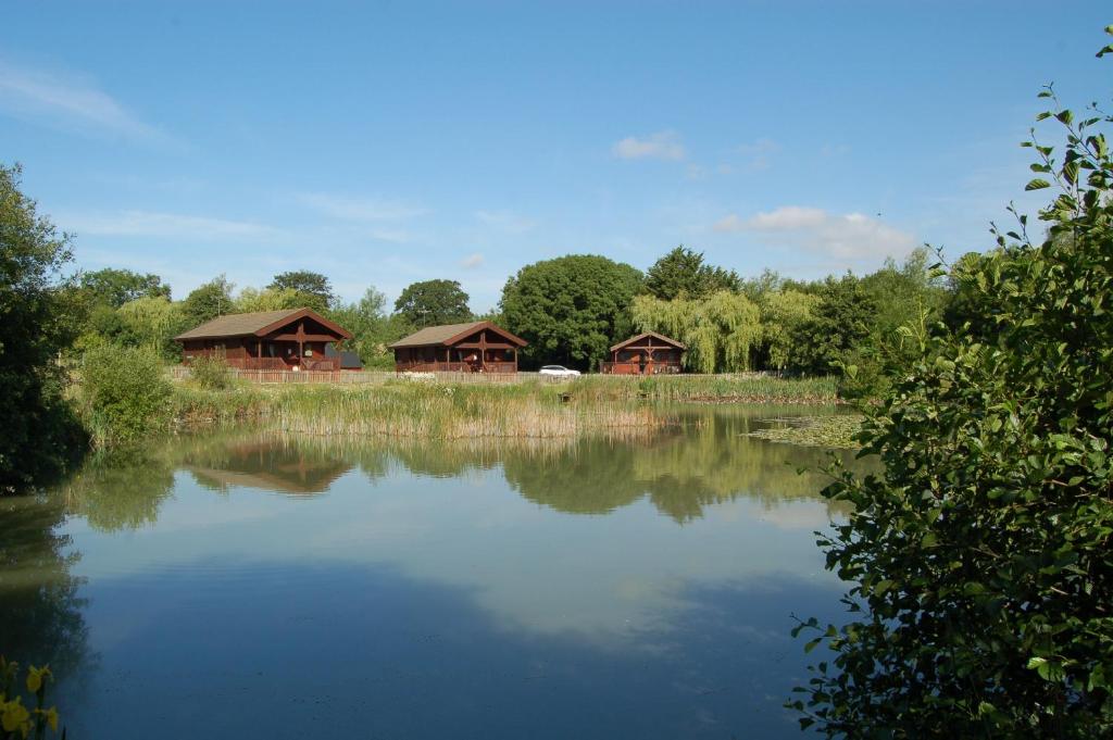 mit Blick auf einen See mit zwei Pavillons in der Unterkunft Watermeadow Lakes & Lodges in North Perrott