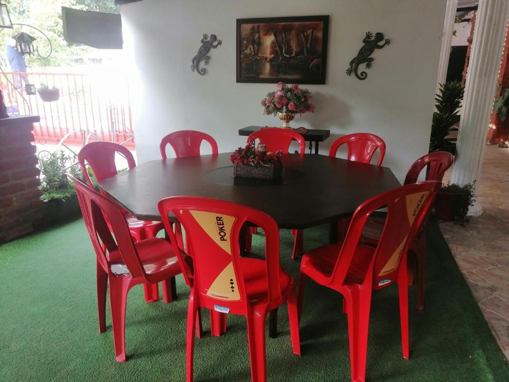 a red dining room table and red chairs at Casa campestre Rancho San Juan in El Pantano