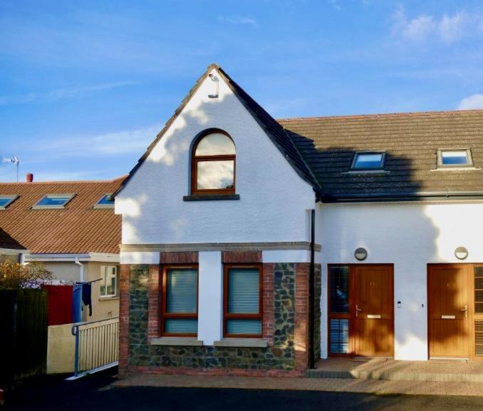 Casa blanca con ventana y puerta en Atlantic View Coach House, en Portstewart