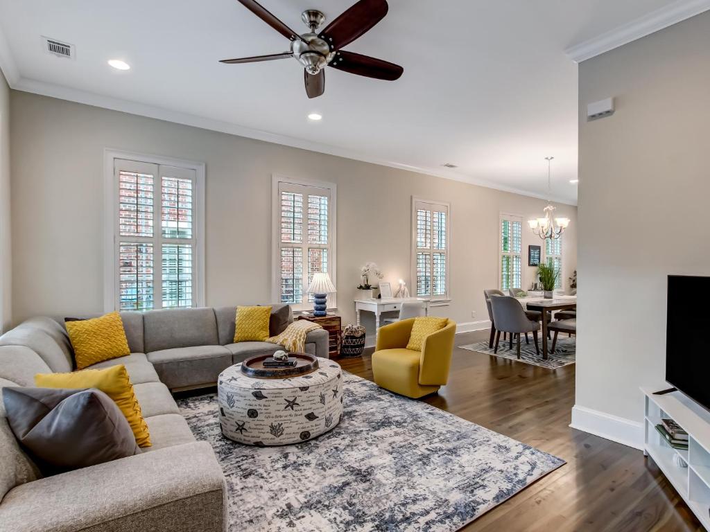 a living room with a couch and a ceiling fan at Gorgeous Home by Crawford Square w Private Parking, Heated Pool Access by Southern Belle Savannah in Savannah