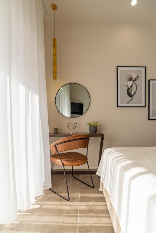 a bedroom with a desk with a mirror and a bed at Samos Tropic Apartments in Ríva