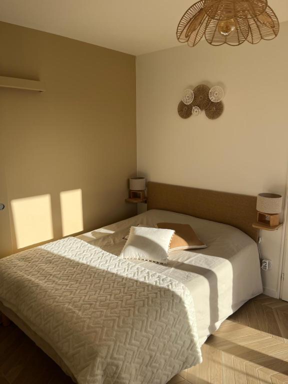 a bedroom with a large white bed with a fan at Studio tout confort Annecy in Annecy