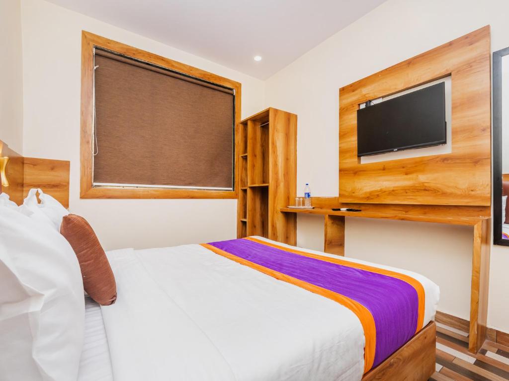 1 dormitorio con 1 cama blanca y TV de pantalla plana en Hotel Era Mumbai en Bombay