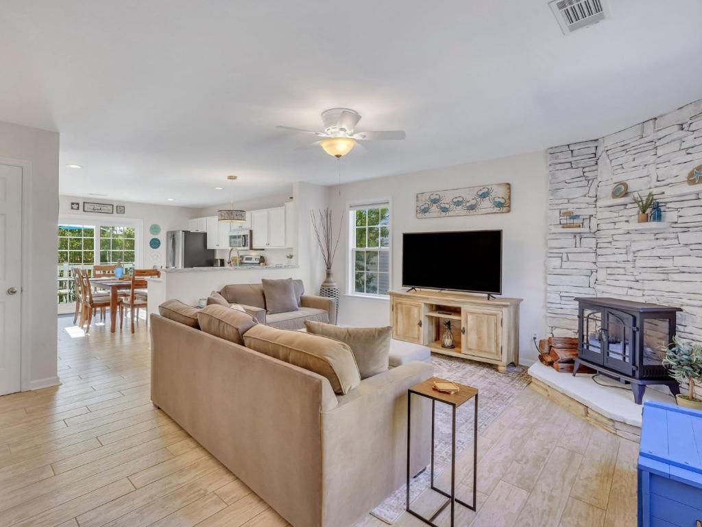 a living room with a couch and a fireplace at Peaceful Beach Vacation, Heated Pool Access, Walk to Restaurants & More! in Tybee Island