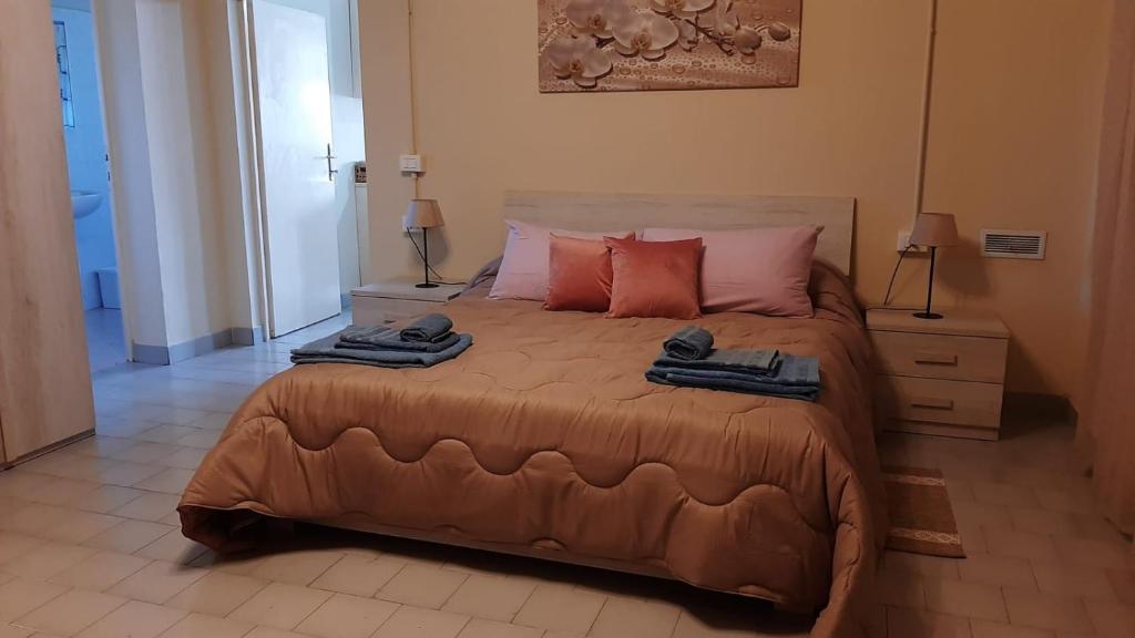een slaapkamer met een groot bed en 2 handdoeken bij La casetta di Lore in Sassetta