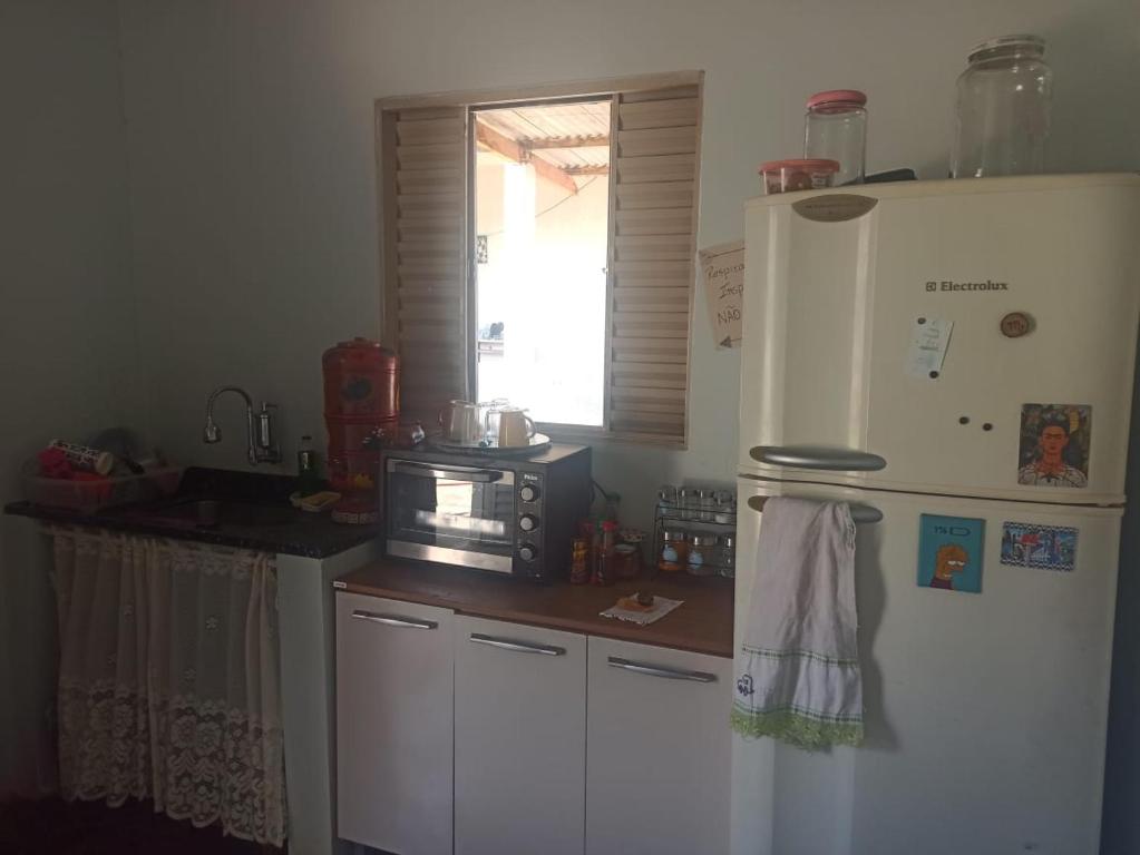 a kitchen with a white refrigerator and a microwave at A silenciosa in Brasília