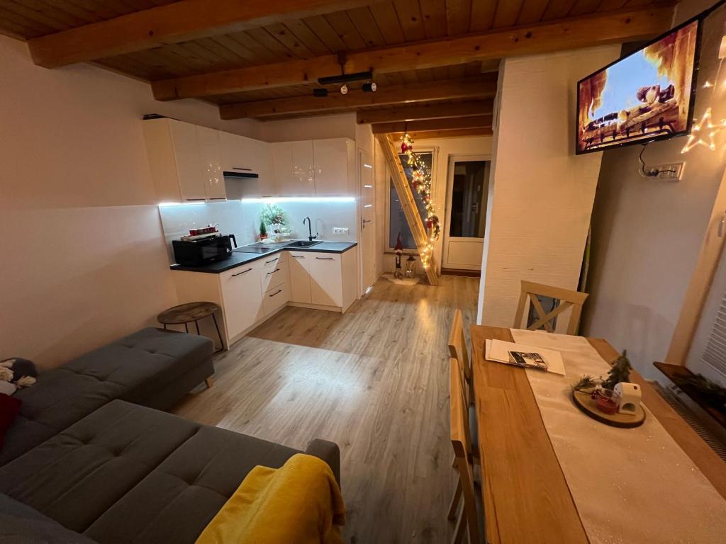 ein Wohnzimmer mit einem Sofa und einem Tisch in der Unterkunft Domek nad Popradem in Muszyna