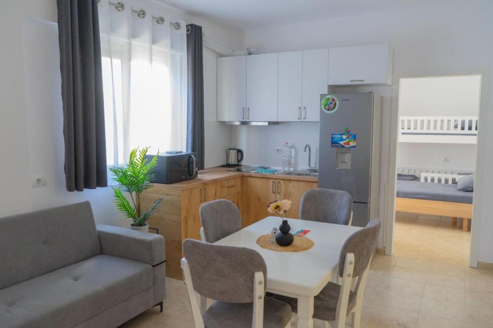 eine Küche und ein Wohnzimmer mit einem Tisch und einem Sofa in der Unterkunft ViVo Beach Apartment in Durrës